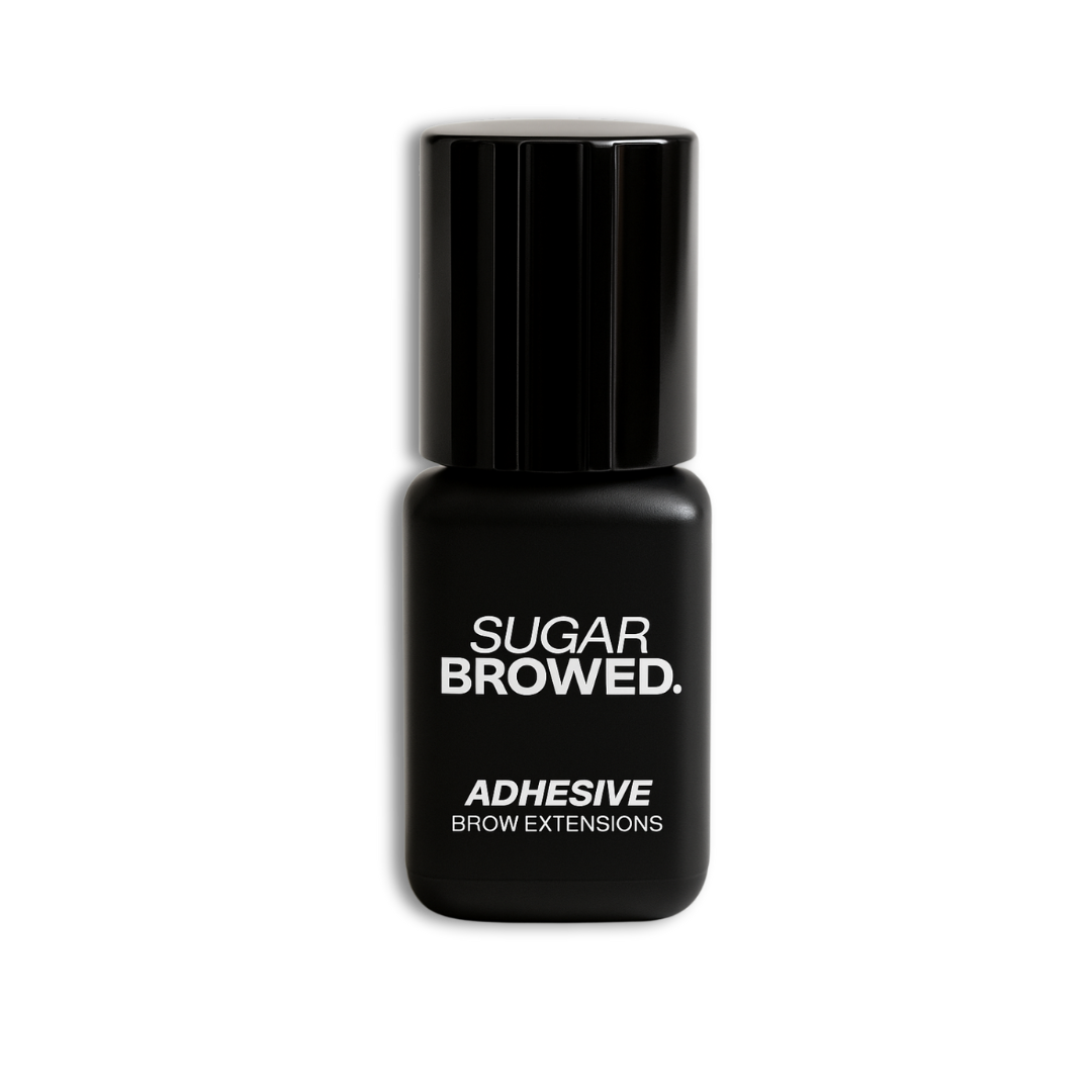 Black bottle of SUGAR BROWED. Adhesive for brow extensions on clean studio background – professional eyebrow glue for long-lasting results