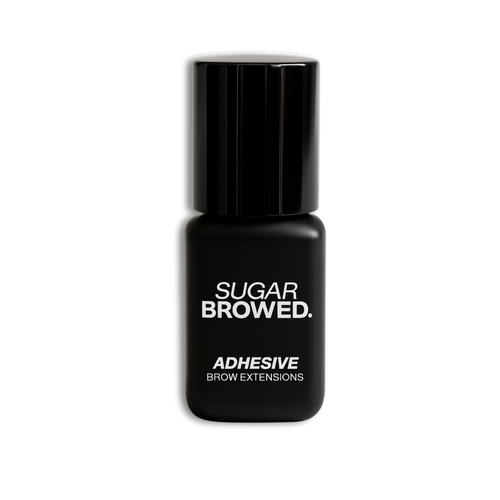 Black bottle of SUGAR BROWED. Adhesive for brow extensions on clean studio background – professional eyebrow glue for long-lasting results