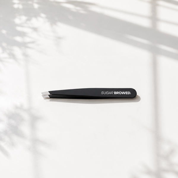 Professional black slant-tip tweezers for precise eyebrow shaping and hair removal – sleek, matte finish